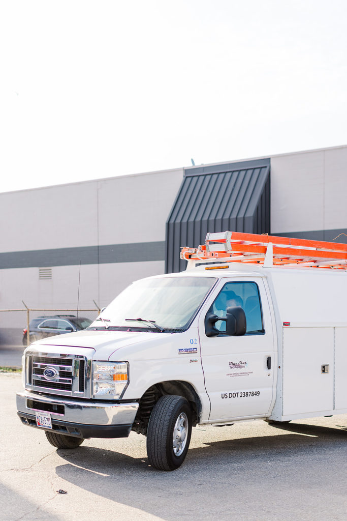 A white company truck parked outside a building